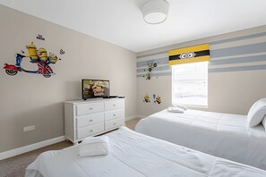 A bedroom with two beds, a dresser, and Minion-themed wall decorations. - Charming 4BR w/ Pool Near Disney - Storey Lake (Kissimmee)