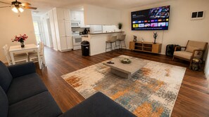 A modern living room with a sofa, coffee table, and a TV mounted on the wall. - Ocean Escape | Beach Front Getaway, Steps to Sand (Redondo Beach)