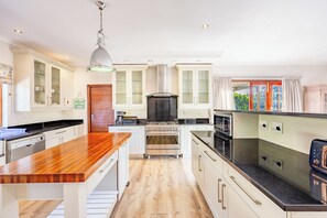 A modern kitchen with a central island, stainless steel appliances, and a view to the outside.