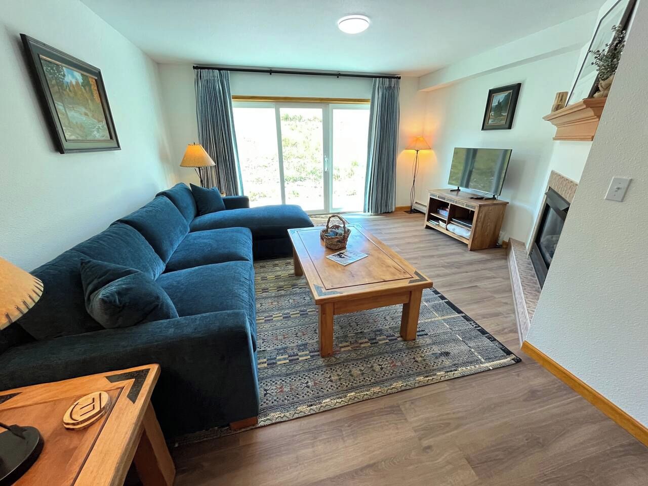Un salon moderne avec un canapé, une table basse et un téléviseur.