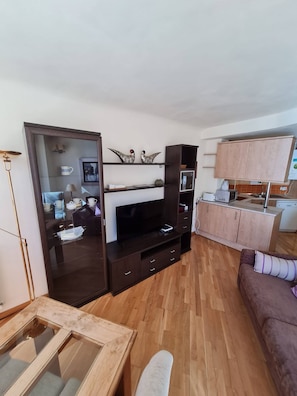 A modern living room with a TV, wooden cabinets, a glass coffee table, and a sofa. - Great Apartment in Madrid (Madrid)