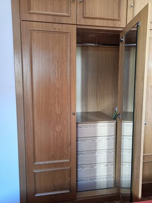 A wooden wardrobe with multiple compartments and a mirrored door. - Flat with parking in the center of Las Rozas (Las Rozas)