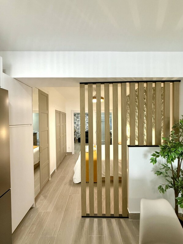 A modern interior with a kitchen, a dining area, and a living space separated by a wooden partition. - Fabulous Apartment in Madrid (Madrid)