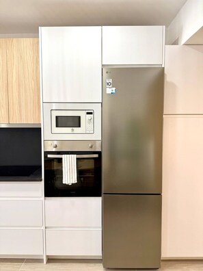 A kitchen with a built-in microwave, oven, and a stainless steel refrigerator. - Fabulous Apartment in Madrid (Madrid)