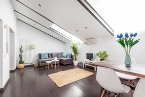 A modern living space with a sofa, coffee table, dining table, and chairs. - Cool urban loft at Madrid's heart. Malasaña. (Madrid)