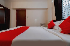 Habitació d'hotel amb un llit, un armari, una porta i una finestra.