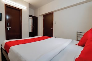 Habitació d'hotel amb un llit, un armari i un mirall.