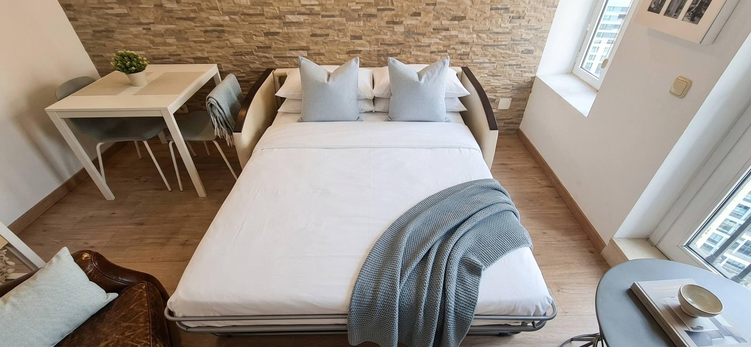 Un dormitorio con cama, escritorio y silla.