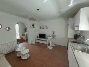 A modern kitchen with white cabinets, a built-in oven, and a stainless steel sink. - Urban Serenity Apartment (Madrid)