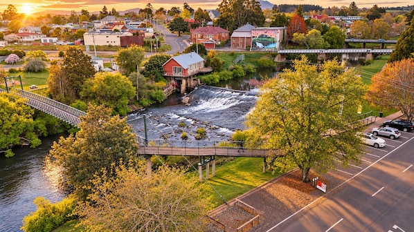 A river with a bridge, a parking lot, and buildings in the background.