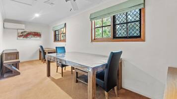 Un espace repas comprenant une table, des chaises et un ventilateur de plafond.