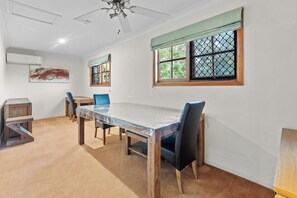 A dining area with a table, chairs, and a ceiling fan.