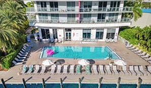 A hotel with a rooftop pool, multiple balconies, and sun loungers. - BW Resort 2BR APT - Beach Access - Fitness Center (Hallandale Beach)