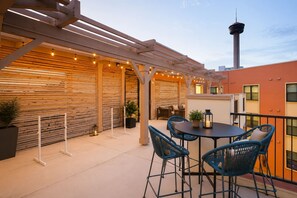 Eine Außenpatio mit Pergola, Sitzbereich und Blick auf einen Turm.