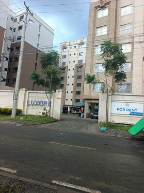 A multi-story building with a sign for 'LUXOR' and a 'FULLY FURNISHED UNFurnished Units FOR RENT' sign. - Cozy Studio apartment near JKI Airport and SGR in Nairobi perfect for your stay (Nairobi)