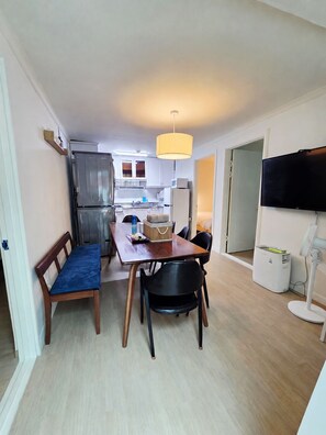 A compact living space with a dining area, kitchenette, and a television. - 10 min to Gocheok Sky Dome, 30 min to Hongdae, Entire home, 2 baths, BBQ yard. (Seoul)