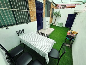 A small outdoor dining area with a table and chairs, a small garden, and a blue door. - 10 min to Gocheok Sky Dome, 30 min to Hongdae, Entire home, 2 baths, BBQ yard. (Seoul)