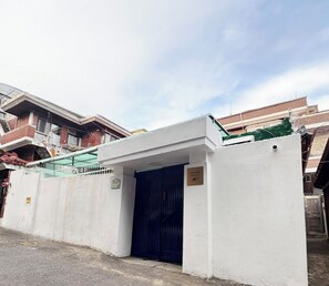 A building with a dark blue door, a white wall, and a sign with numbers. - 10 min to Gocheok Sky Dome, 30 min to Hongdae, Entire home, 2 baths, BBQ yard. (Seoul)