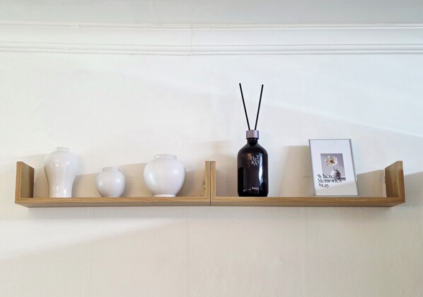 A wooden shelf with three white vases and a black bottle with two black sticks. - 10 min to Gocheok Sky Dome, 30 min to Hongdae, Entire home, 2 baths, BBQ yard. (Seoul)