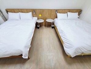 A hotel room with two single beds, a small round table with a vase of flowers, and a trash bin. - 10 min to Gocheok Sky Dome, 30 min to Hongdae, Entire home, 2 baths, BBQ yard. (Seoul)