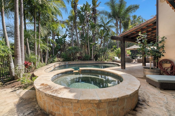 A circular stone pool surrounded by tropical vegetation and a wooden pergola. - Mediterranean style retreat. (Solana Beach)