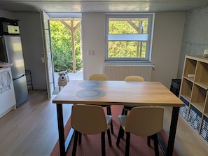 A dining area with a table, chairs, and a view of the outdoors.