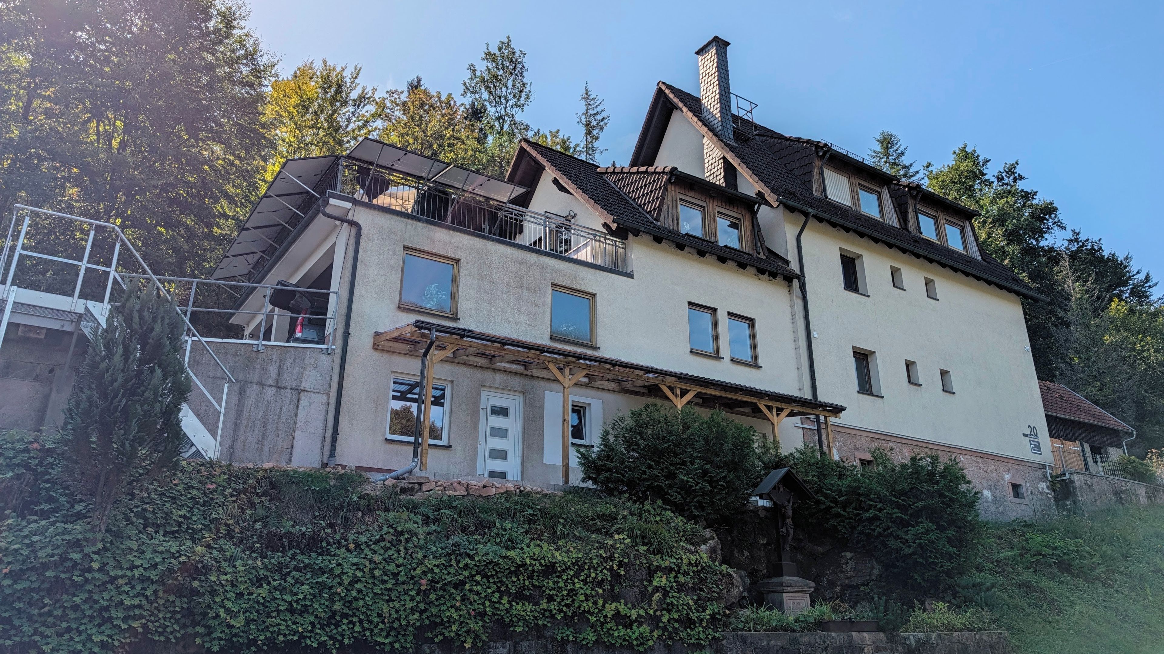 En bygning med flere etager, en balkon, en skorsten og en statue.