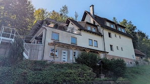 Ein mehrstöckiges Gebäude mit einem Balkon, einem Schornstein und einer Statue.