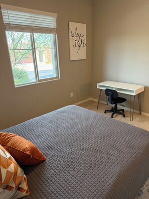 A bedroom with a bed, a desk, and a window. - 
Luxurious Desert Oasis in gated Dove Mountain community with pool and hot tub (Marana)