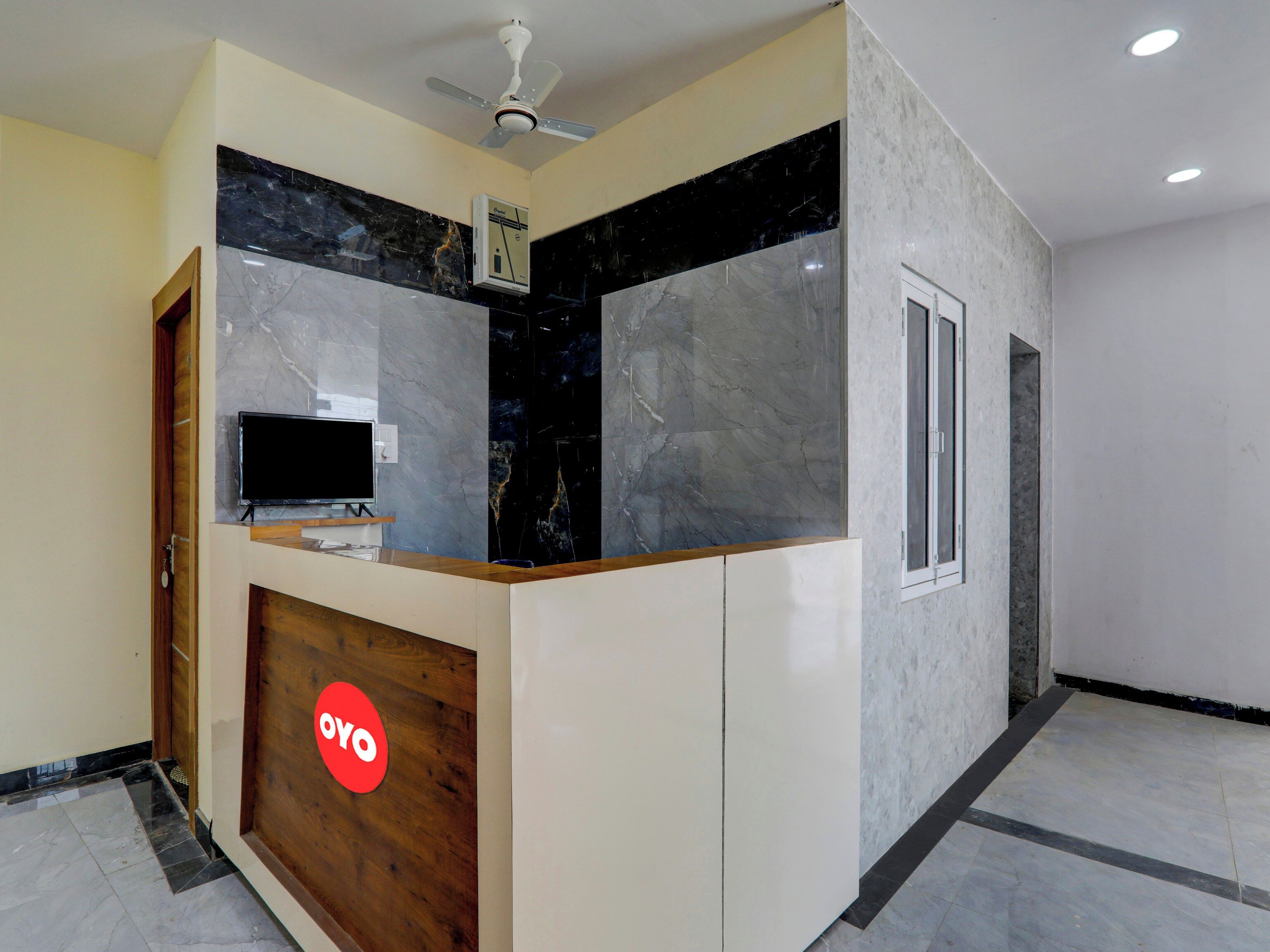 A reception desk with a flat-screen TV, a ceiling fan, and a 'YOYO' logo.