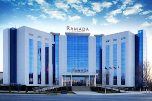 A modern building with the name 'RAMADA' prominently displayed on the facade. - Ramada by Wyndham (Nukus)