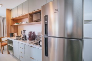 A modern kitchen with a stainless steel refrigerator, a microwave, and a coffee maker. - Nixxus 216 (Ipojuca)