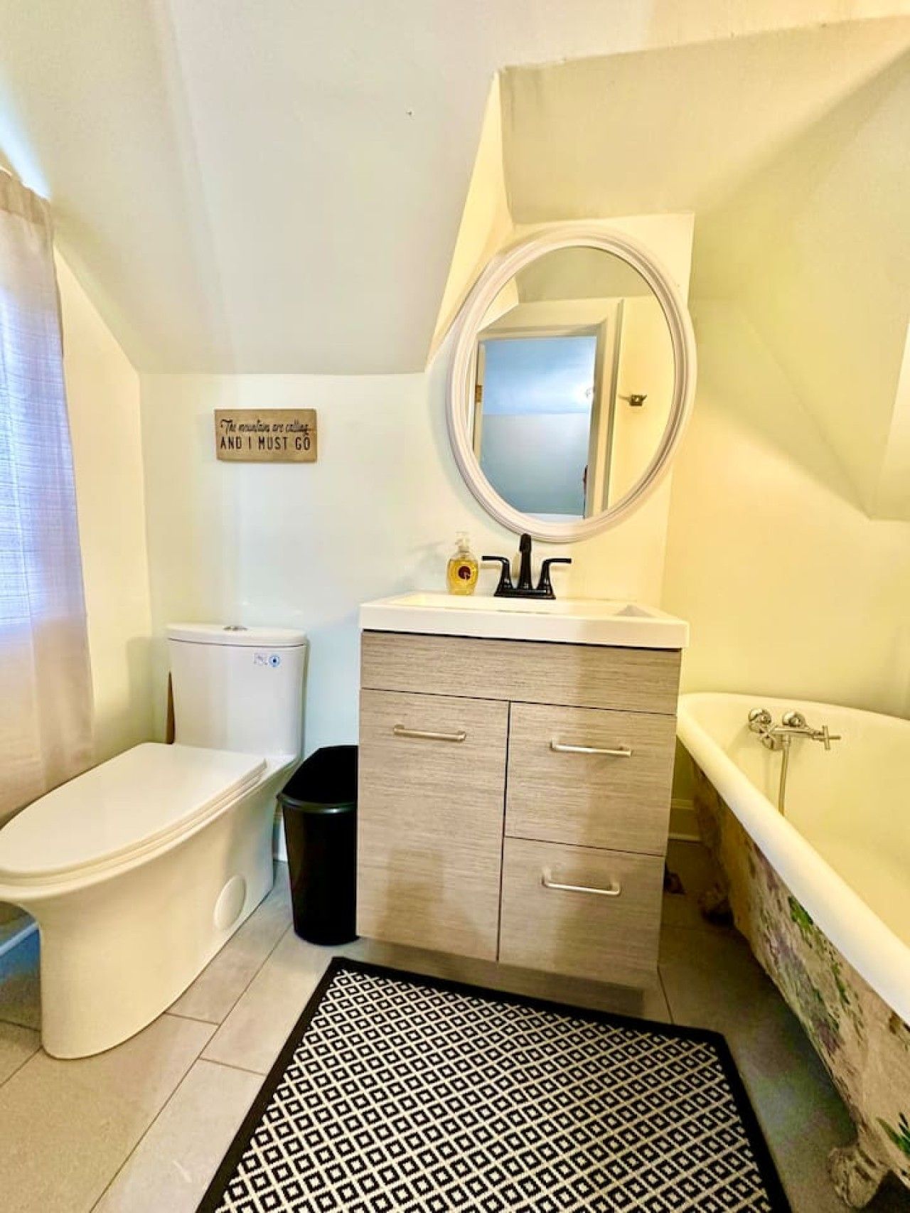 Une salle de bain comprenant des toilettes, un lavabo, un miroir et une baignoire.