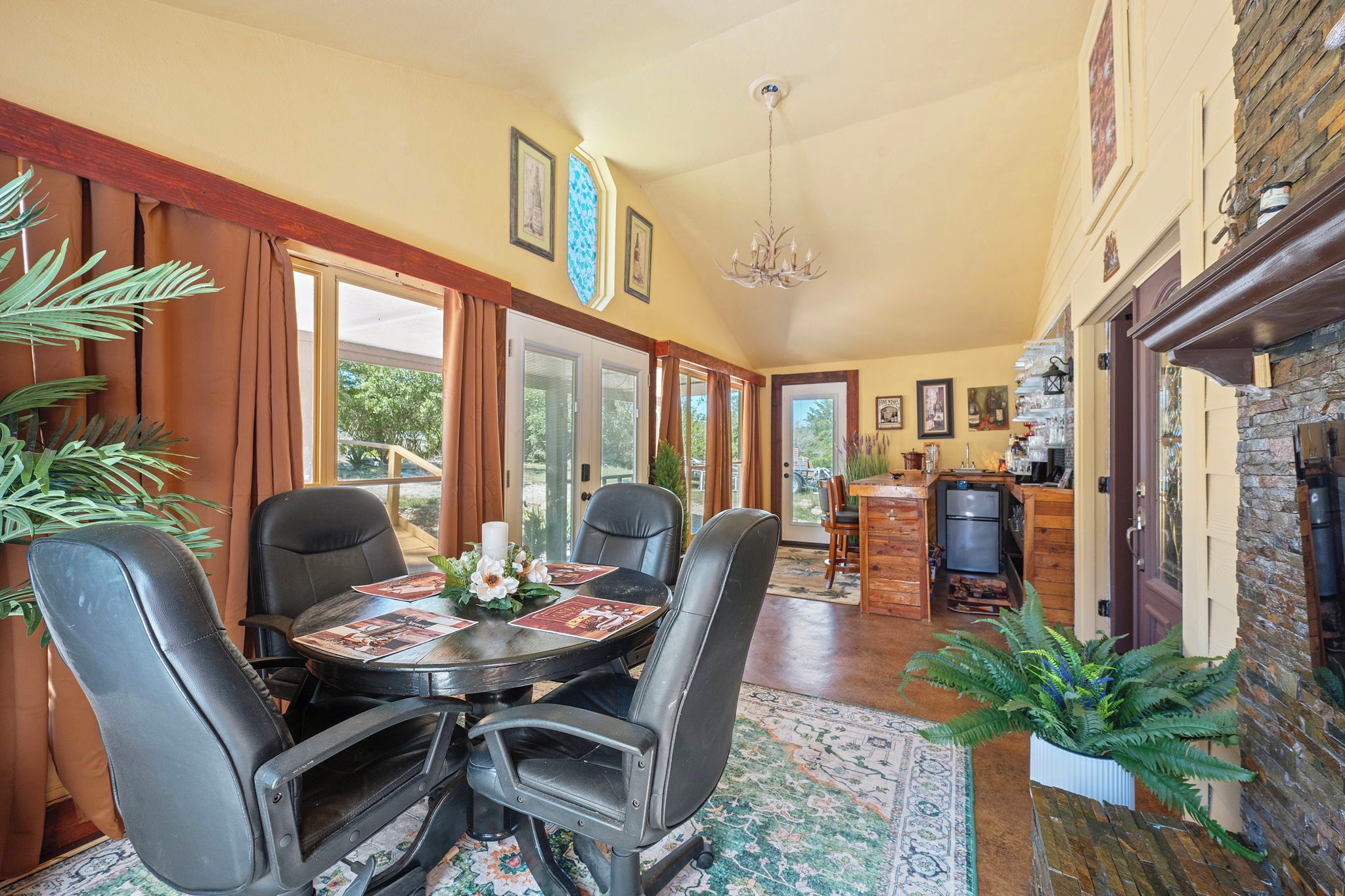 A dining area with a round table, chairs, and a chandelier.