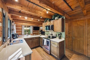 A kitchen with wooden cabinets, a stainless steel refrigerator, an oven, and a microwave. - A River Runs Through It- Boone (Vilas)