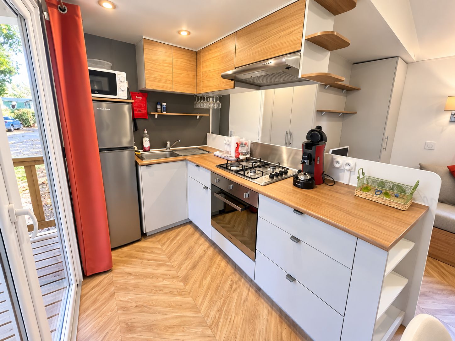 A compact kitchen with a microwave, gas stove, and wooden cabinets.