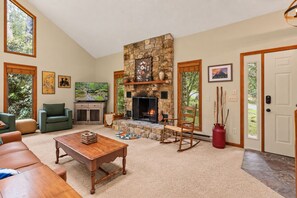 A spacious living room with a stone fireplace, comfortable seating, and a television. - "Shanty Springs Retreat" -  Your Creekside Oasis (Banner Elk)