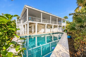 A two-story house with a pool, surrounded by tropical plants. - Luxury Gulf-Front Escape 4 Bedrooms, Private Pool & Stunning Views (Sanibel)
