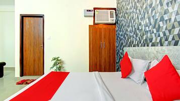 Habitación de hotel con cama, armario, calefacción y pared con estampado.