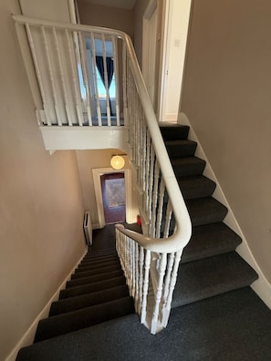A staircase with a handrail and a landing with a door. - Sunny 2-Bed Triplex with Private Terrace (Greater London)