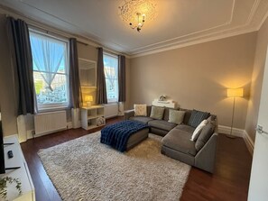 A living room with a sofa set, a coffee table, a rug, and a lamp. - Sunny 2-Bed Triplex with Private Terrace (Greater London)