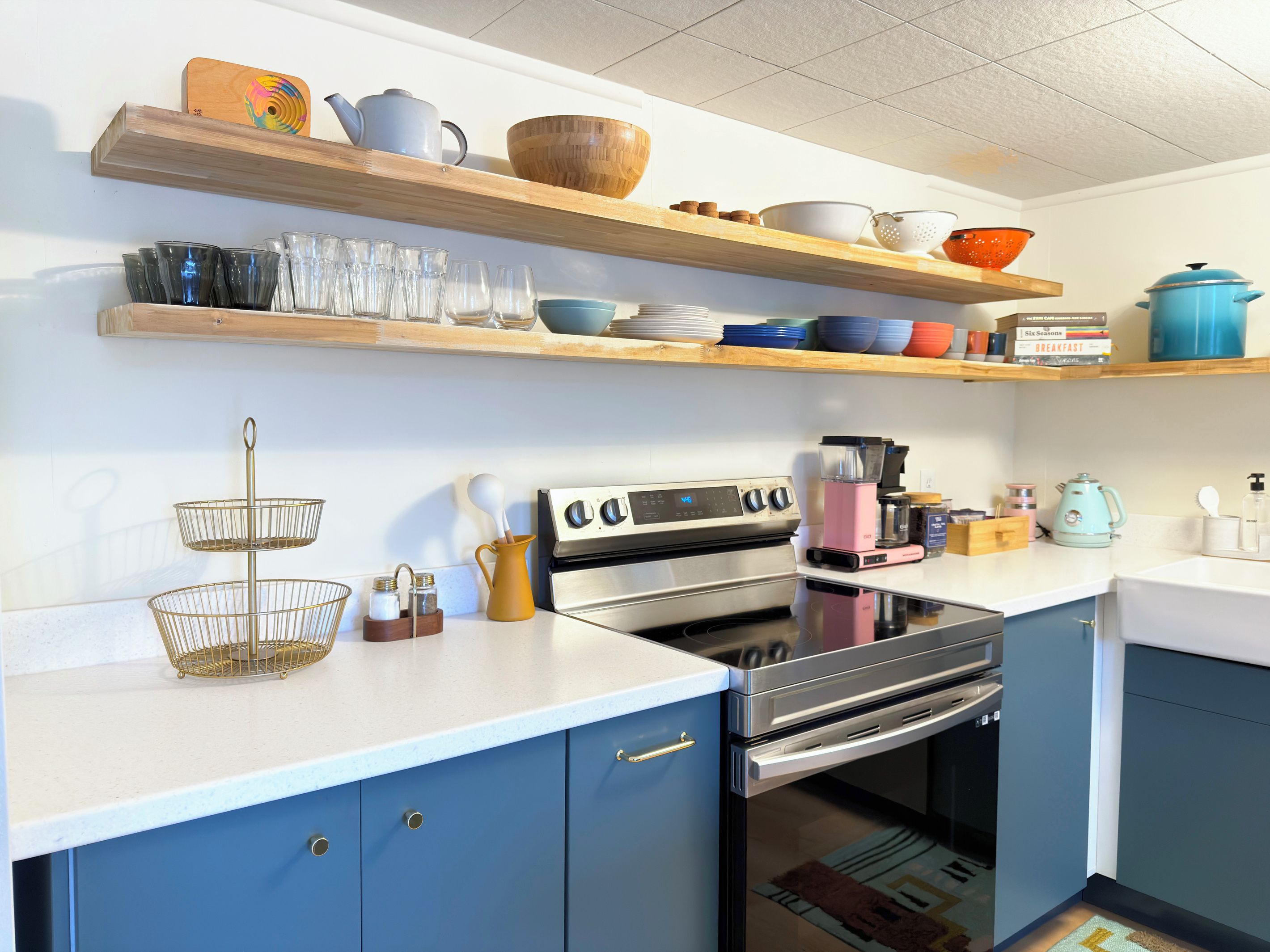 A kitchen with a double oven, a coffee maker, and various kitchen utensils on the counter.