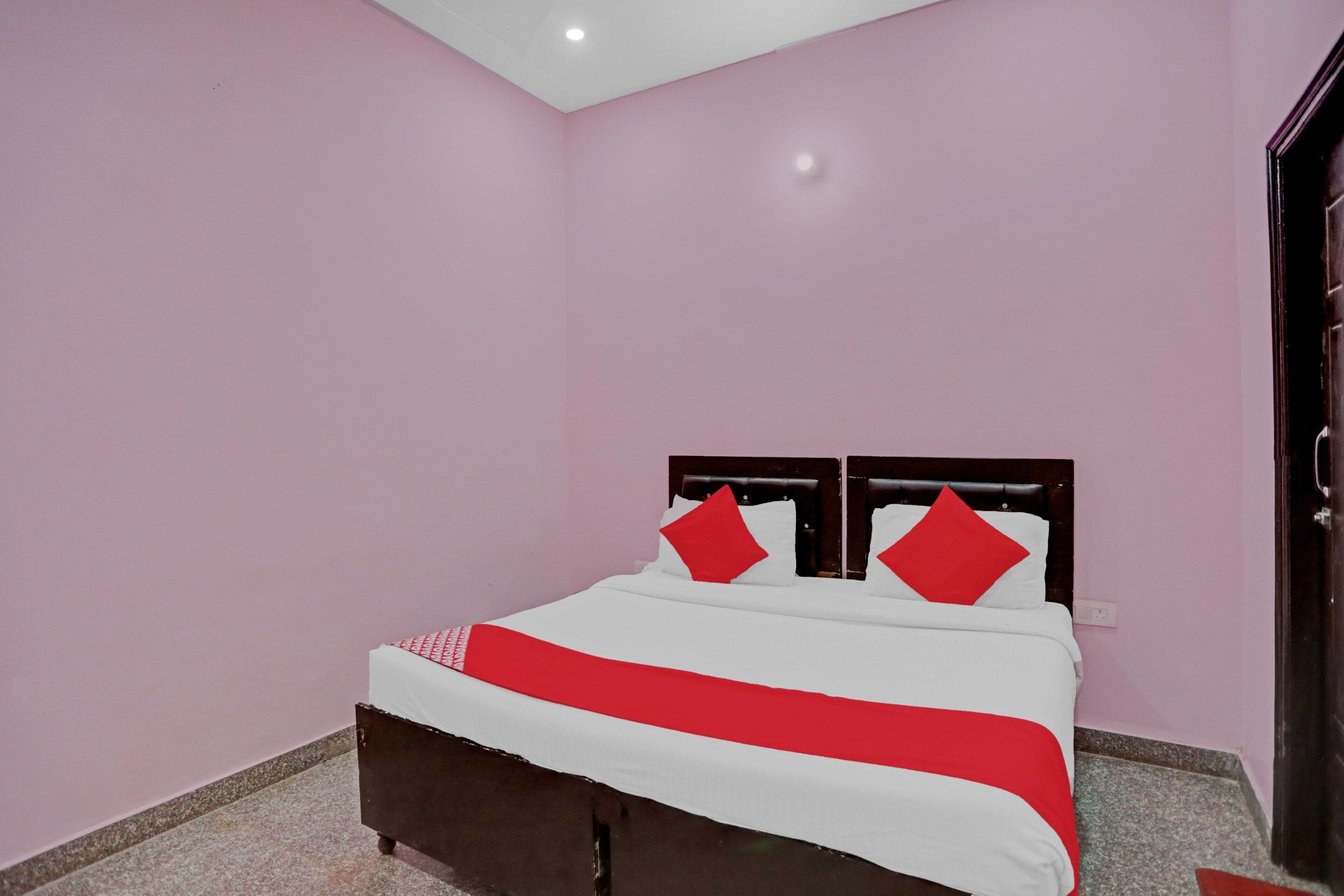 A bedroom with a bed, a headboard, and a door.