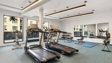 A gym with treadmills, weights, and exercise equipment.