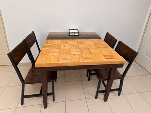 A rectangular dining table with a woven pattern tabletop, surrounded by four chairs with dark wooden frames and seats. - New Listing (Monterrey)