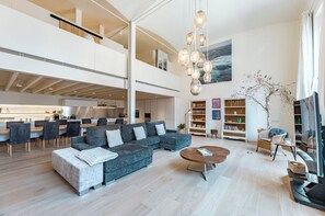 A spacious living area with a large sectional sofa, a coffee table, and a dining area with chairs. - Luxury apartment Notting Hill (London)