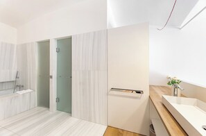 A modern bathroom with a large mirror, a built-in sink, and a shower area. - Luxury apartment Notting Hill (London)