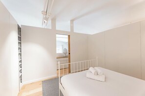 Ein Schlafzimmer mit einem Bett, einem weißen Kleiderschrank und einer eingebauten Regaleinheit.