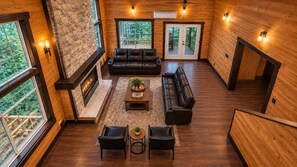 A spacious living area with a fireplace, leather sofas, and a coffee table.