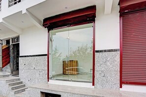 A building entrance with a glass door, steps leading up to it, and a red awning. - HOtel O The Clarks Inn (Noida)